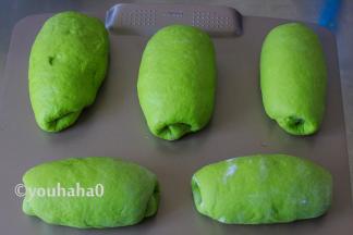 将面团从上往下轻轻卷起，捏紧收口成橄榄形，依次做好全部面团，摆放在烤盘上进行二次发酵。