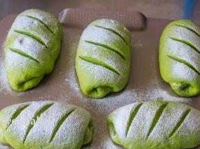 在二次发酵到位的面团上撒面粉，割上刀口。