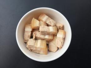 煮好的五花肉切成小方块。