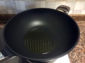 热锅倒油烧至八成热。