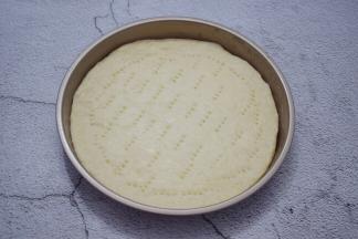 然后放入披萨盘，用叉子在饼皮叉些小洞