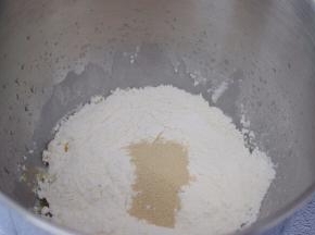 把材料都放入和面桶，顺序为纯牛奶、鸡蛋液、玉米油，糖和盐对角放，然后放面粉，酵母放最上面