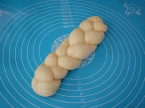 编出一个三股辫子，前后要捏归紧，然后放在底部，压住，这样发酵时不会松开