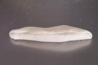 然后在此旋转360度，上边再向中间折三分之一，然后捏紧两个收边