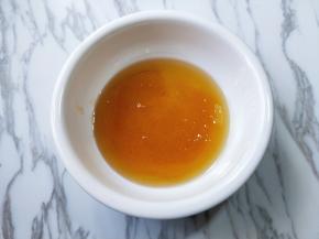 将转化糖浆放入一个大口器具中，加入枧水，用手动打蛋器打至均匀。