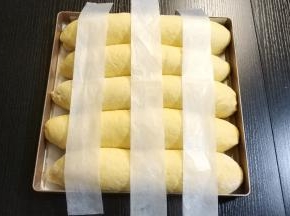 发酵两倍大后拿出，把油纸剪出等宽的三个长方形窄条，如图摆好