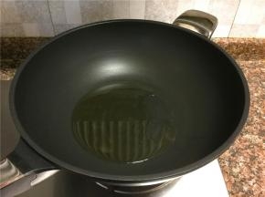 热锅倒油烧至八成热。