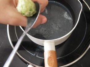 锅里放适量水烧开，然后转小火，用虎口挤出丸子。