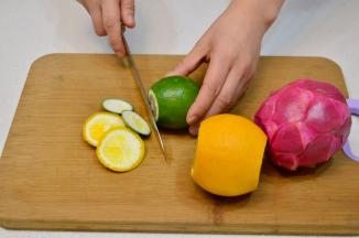 将柠檬和橙子用盐擦洗干净后去除2头，红肉火龙果去皮，白肉火龙果洗干净后去枝叶。