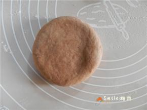 收口向下，按扁，稍微擀一下，擀成圆饼形的面团。
