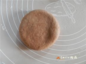收口向下，按扁，稍微擀一下，擀成圆饼形的面团。