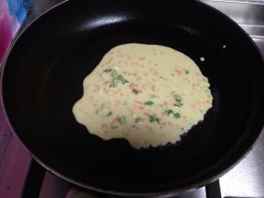 然后用勺子舀面糊放入锅中