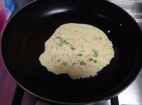 然后用勺子舀面糊放入锅中