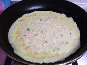 摊上薄薄的一层，尽量把饼摊圆，一直保持中小火慢慢烙