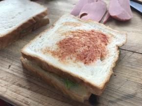 再加一片吐司，抹一层番茄酱，加几片切好的香肠，最后加一层吐司