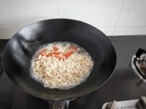 趁着锅内的余油，加入番茄翻炒一会，加入适量的水，加入泡面中的调料，等水开了加入泡面煮几分钟