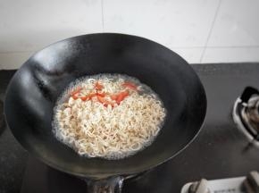 趁着锅内的余油，加入番茄翻炒一会，加入适量的水，加入泡面中的调料，等水开了加入泡面煮几分钟
