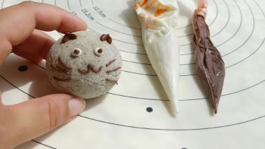 出炉放凉后，把黑、白巧克力隔水加热化开装进裱花袋里装饰上表情即可。