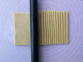 用刮板切去不规则的边后，用刀切成约1cm宽度的长条状