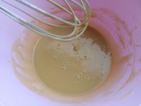 把咖啡蛋黄液慢慢的倒入放凉的面糊里，搅拌均匀。