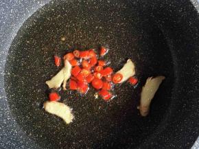 油热，爆香姜片、红辣椒，红辣椒经过油炒，辣味更足、更香。