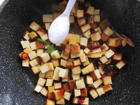 再加入盐，翻炒至熏干边缘微微变得焦黄色。