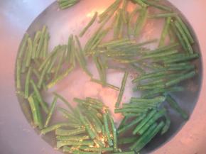 切成段，开水锅中加入一勺盐，几滴食用油，放入红豆段焯水3～4分钟