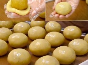 取一份饼皮压扁后包入莲蓉蛋黄馅料，用虎口把饼皮慢慢向上推，最后揉搓至饼皮完全包裹住馅料，收紧口，间隔开放在烤盘。