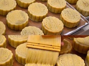 5分钟后取出月饼，烤盘放至网架晾几分钟，稍凉后在月饼表面轻轻刷一层薄薄的蛋黄液。