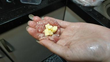 已腌制好的肉末拿出一小块，如图塞入芝士碎