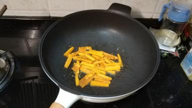 锅里热油放入蒜盐、糖爆香，再放南瓜翻炒