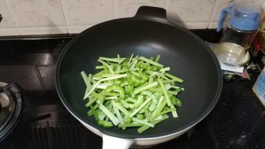 锅里热油放入蒜盐、糖、干辣椒粒爆香，再倒入芹菜、苦瓜
