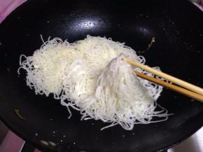 炒锅另加油，放入裹上面粉的粉条翻炒，为防止粉条粘连，用锅铲和筷子一 起，边翻边抖散，盛出备用