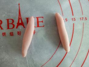 分完身体和头部剩下的面团分别分成两份2克的面团和2份2.5克的面团，2.5克的面团搓成水滴状做兔子的耳朵