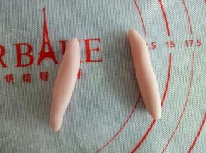 分完身体和头部剩下的面团分别分成两份2克的面团和2份2.5克的面团，2.5克的面团搓成水滴状做兔子的耳朵