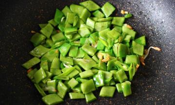 加入切好的芸豆，继续大火翻炒片刻