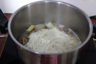 过冷水的面条，放入锅里，并用筷子拌均。