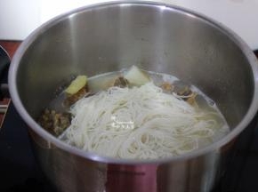 过冷水的面条，放入锅里，并用筷子拌均。