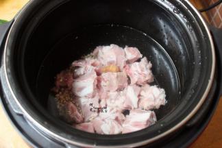 把沥干水的薏米、洗净的排骨，倒入压力锅，加适量的清水，按煲骨头键功能，大约30分钟。每个电压力锅不同，煲煮的时间略有差异。