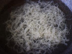 锅中倒入适量清水煮沸后，放入一块米粉、煮1分钟散开即可关火，捞出沥干水分备用