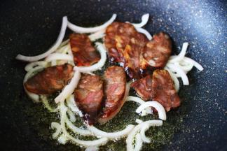 加入切片的风干肠，继续大火翻炒片刻