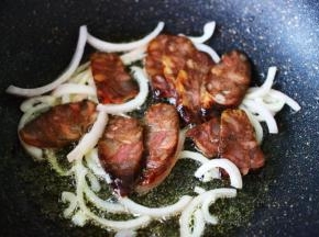 加入切片的风干肠，继续大火翻炒片刻