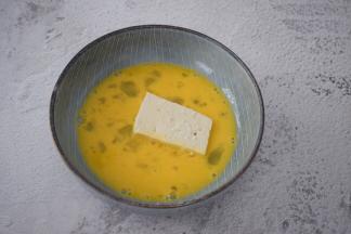 把豆腐放入蛋液中沾裹上蛋液