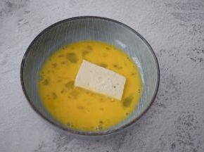 把豆腐放入蛋液中沾裹上蛋液