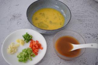 青红椒洗净切丁，蒜姜切末，葱切葱花，鸡蛋打散备用，把酱汁材料全加入碗中调成酱汁备用