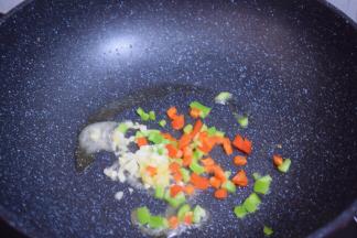 锅中留少许底锅，放入蒜姜和青红椒炒出香味