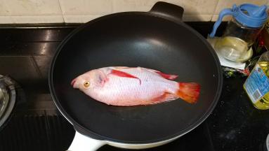 锅里热油，放入立鱼煎至微黄