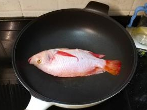 锅里热油，放入立鱼煎至微黄