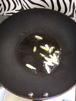 锅中放入油，烧热后，放入葱炒香。