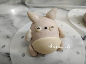 搓两个绿豆般大小的白面，当眼睛。再搓两条黑线，贴到白面上。搓个小黑圆当鼻子。